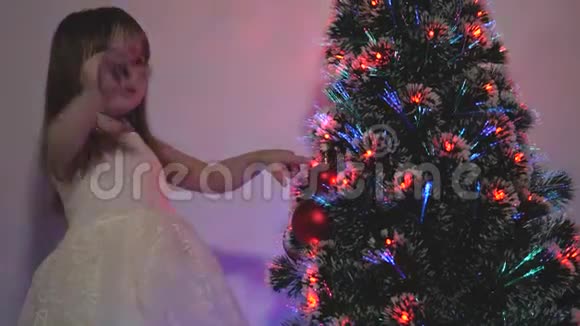 快乐的童年概念孩子们用圣诞球装饰圣诞树小孩在圣诞树旁玩耍视频的预览图