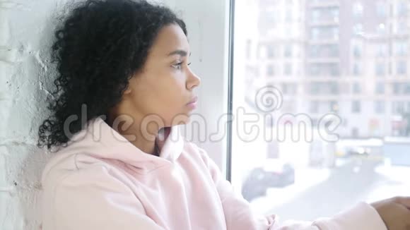 靠近年轻的美国黑人妇女透过窗户看视频的预览图