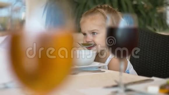 小女孩在咖啡馆外面吃饭视频的预览图