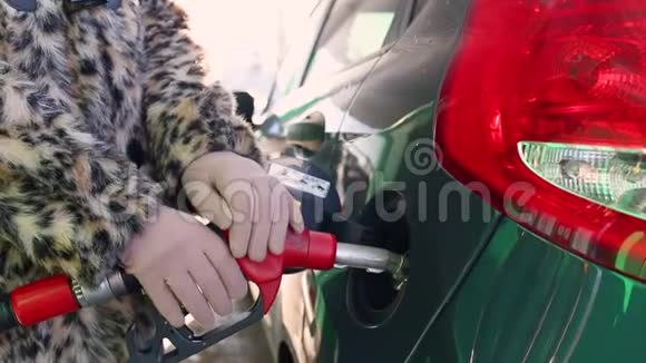 女人在冬天的加油站给她的车加油视频的预览图