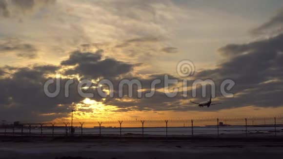 飞机着陆日落蓝天紫色和橙色的云彩在背景中视频的预览图