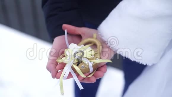 婚礼符号锁在新郎新娘手中新婚夫妇把桥上的锁作为爱情的象征打开挂锁视频的预览图
