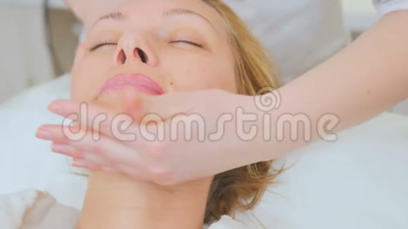 年轻女子在美容诊所的面部按摩中放松视频的预览图