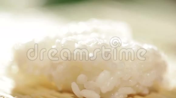 把一块鲑鱼放在米饭上做寿司卷视频的预览图