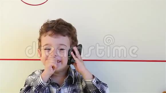 嘲笑小男孩在智能手机上说话视频的预览图