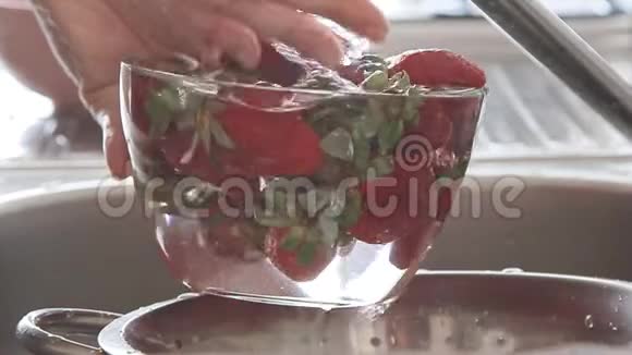 女人在水流下洗草莓视频的预览图