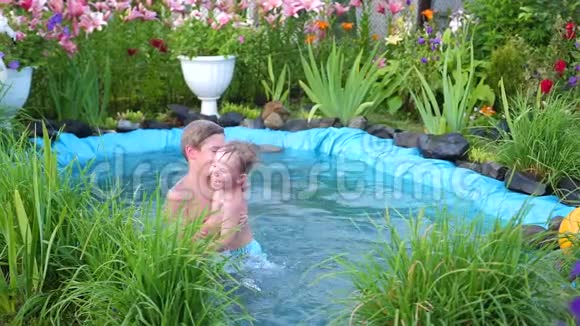 在炎热的夏天孩子们在一个小湖里游泳园花草环湖快乐的童年视频的预览图