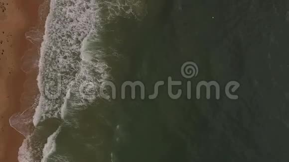 空中无人机观看热带海滩海浪到达海岸热带沙滩上海浪的俯视图视频的预览图