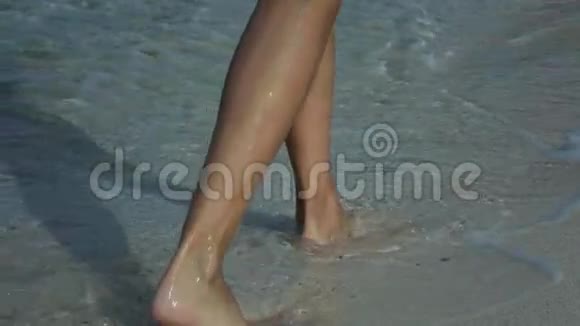 日出时一名女子赤脚在沙滩上行走的慢动作视频视频的预览图