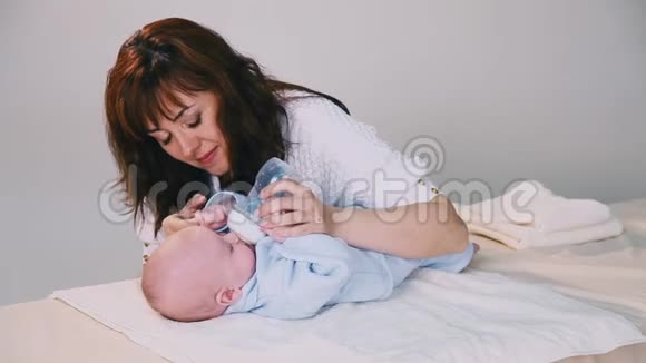妈妈正在用瓶子喂婴儿牛奶视频的预览图