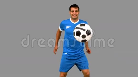 一个英俊的男人在灰色的屏幕上踢足球视频的预览图