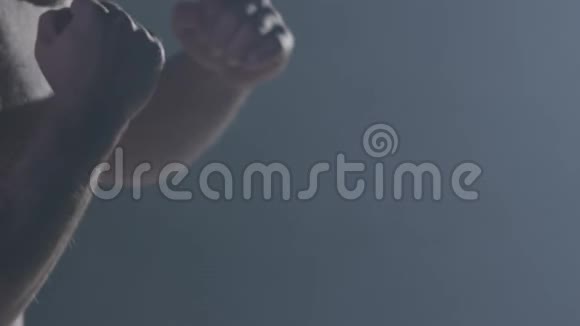 战斗机的轮廓英俊的拳击运动员站在黑暗的背景上戴拳击手套的肌肉男视频的预览图