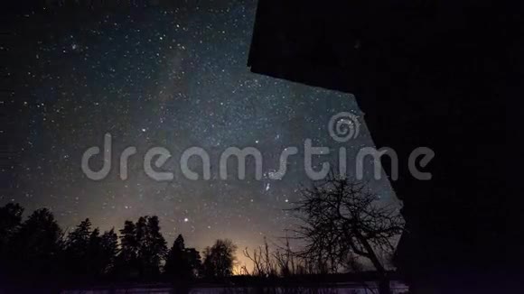 冬季夜晚木材房上星星的时间推移视频的预览图