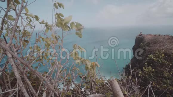 女孩坐在美丽的悬崖上视频的预览图