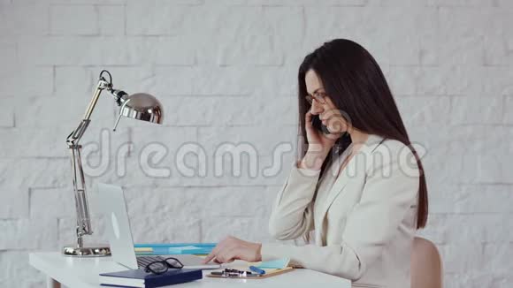 漂亮的年轻女商人上班时打电话来视频的预览图