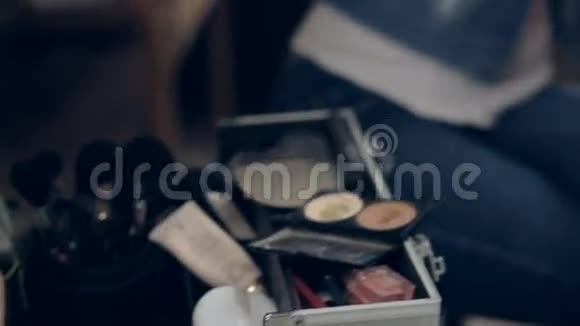 化妆师用刷子在年轻女人的脸上涂妆全景视频的预览图