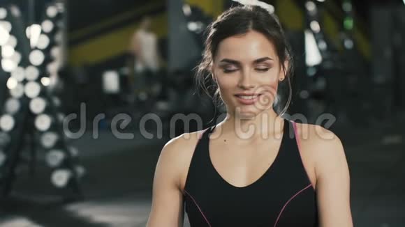 吸引人的年轻女孩在健身房背景下摆姿势视频的预览图