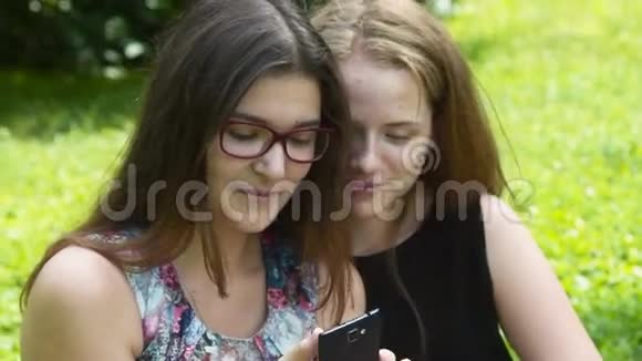 在公园里带手机的快乐少女视频的预览图
