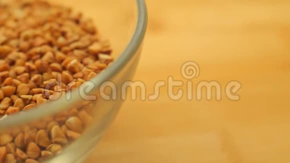 健康的荞麦种子放在木桌上的玻璃碗里宏观顶部视图视频的预览图