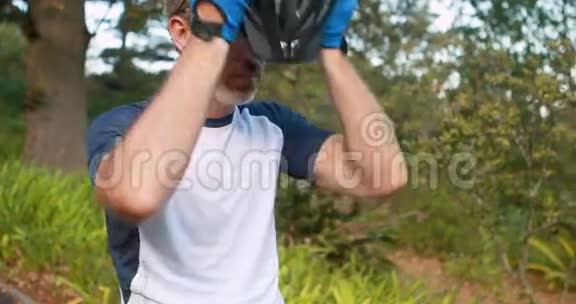 男子骑自行车在农村戴头盔视频的预览图