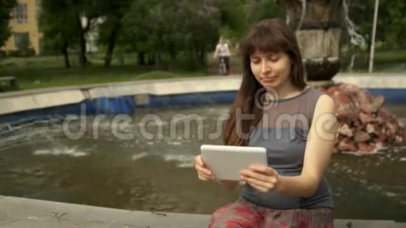 坐在喷泉旁边的女人拿着桌子视频的预览图