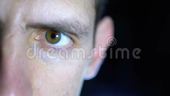 在黑背景电脑上工作的年轻人的眼睛和脸的特写视频的预览图