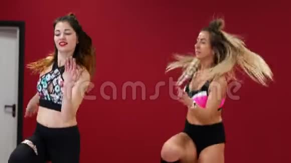 两个漂亮的运动女孩像穿着特殊的健身鞋的袋鼠一样积极地进行燃烧脂肪的锻炼视频的预览图