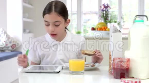 西班牙裔女学生带数字平板吃早餐视频的预览图