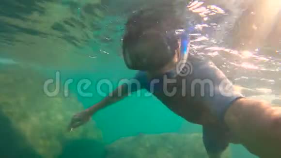 一个年轻人潜水潜到海里的慢镜头视频的预览图