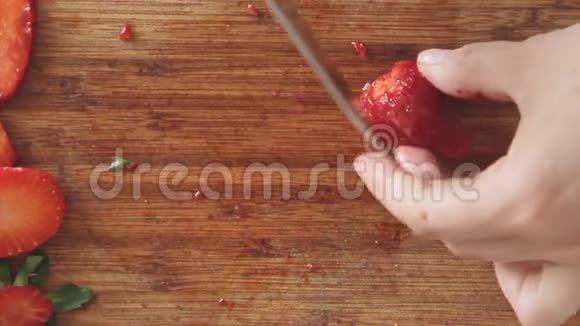 女人用手在木板上切草莓视频的预览图