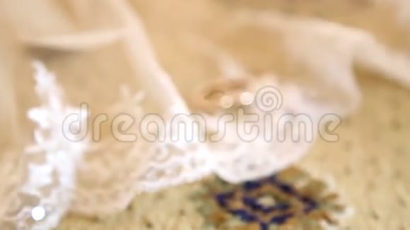 新娘的白色面纱上戴着两枚金色结婚戒指面纱上有两枚结婚戒指面纱上戴着结婚戒指视频的预览图