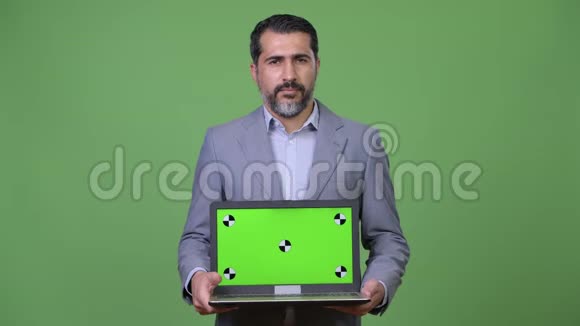 英俊的波斯胡子商人展示笔记本电脑视频的预览图