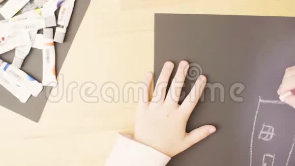 一个女孩在一个房间的桌子上画纸上的蜡笔视频的预览图