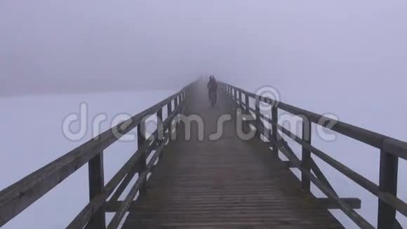 冬季雾中的木桥和自行车视频的预览图