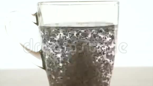 白色背景下浸泡在水玻璃中的辣椒种子视频的预览图