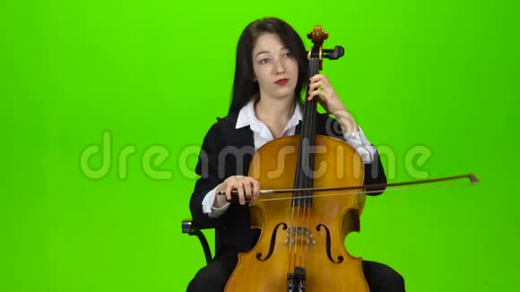 女孩坐着玩大提琴绿色屏幕视频的预览图