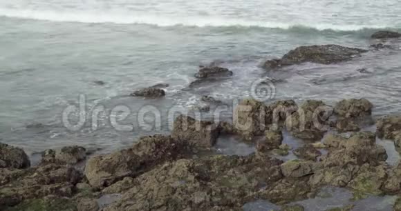平静的波浪在岩石之间移动视频的预览图