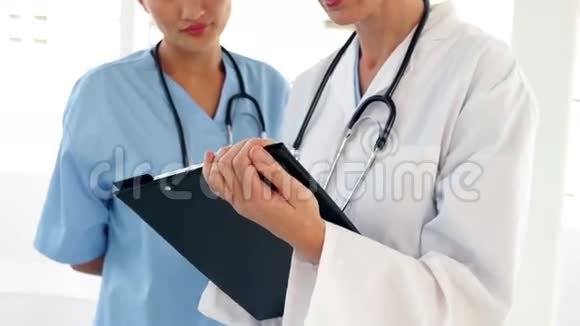 两个医生看着文件看着摄像机视频的预览图