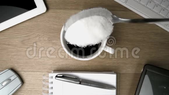 茶匙里的糖掉进桌上的一杯咖啡里视频的预览图