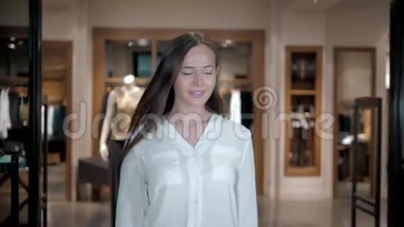 幸福美丽的女人拿着购物袋站在商店里漂亮的白种人女孩在大商场买包视频的预览图