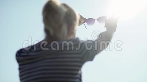 戴太阳镜的女孩看着远处农村的女孩视频的预览图