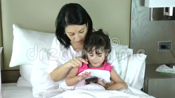 妈妈教她的小女儿玩手机视频的预览图