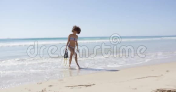 女人在海滩上拿着脚蹼视频的预览图