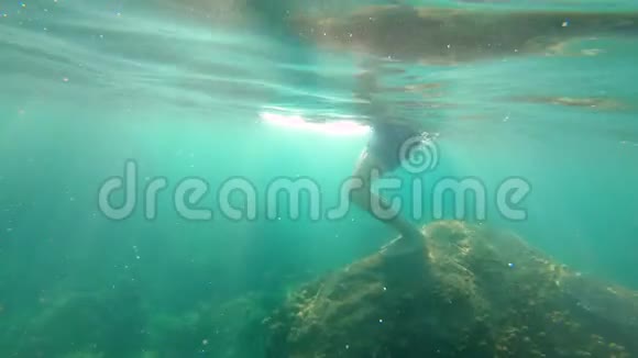 一个年轻人潜水潜到海里的慢镜头视频的预览图