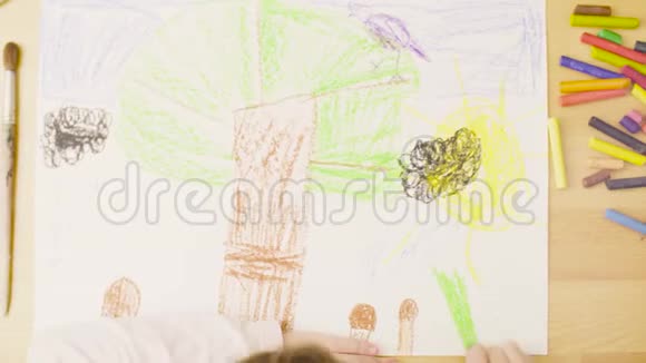 一个女孩在一个房间的桌子上画纸上的蜡笔视频的预览图