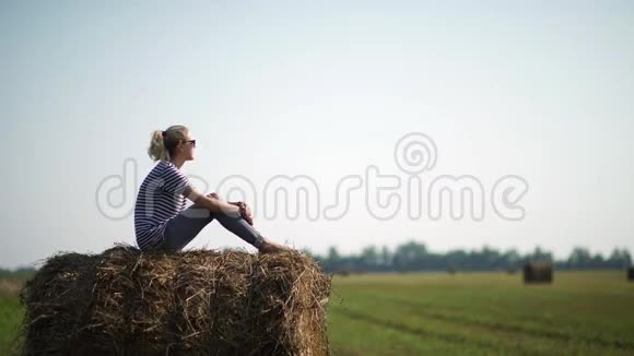农村的女孩漂亮女孩坐在干草堆上视频的预览图