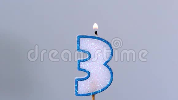 三支生日蜡烛在蓝色背景下闪烁熄灭视频的预览图
