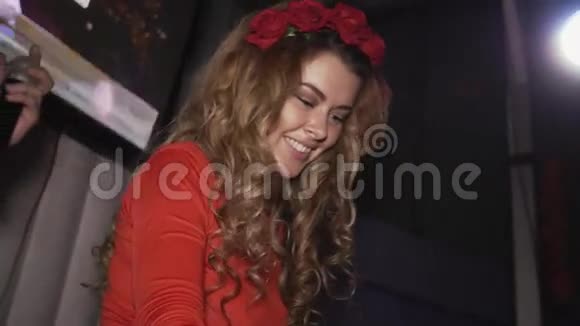 吉女孩穿着红色连衣裙头上的轮辋在俱乐部转盘旋转微笑视频的预览图