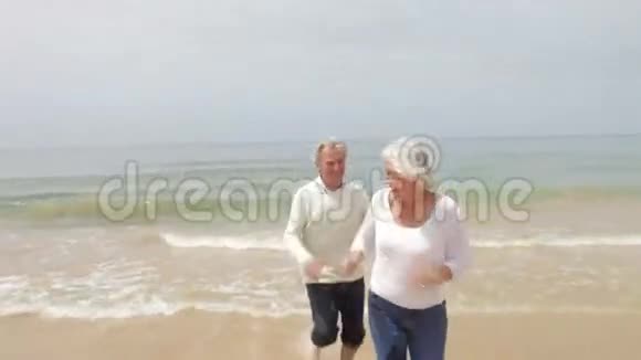在秋季海滩跑步的高级夫妇视频的预览图