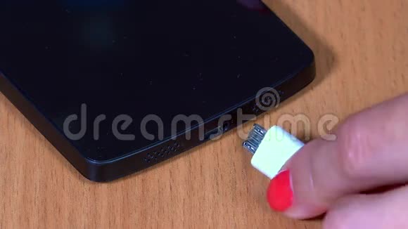 女士手插白色微型USB电缆智能手机视频的预览图
